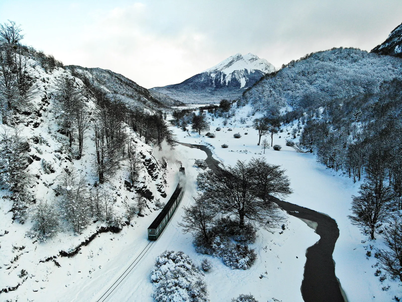 Aerial view of the train crossing a snowy valley in Tierra del Fuego National Park